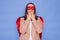 Shocked brown haired woman wearing superhero costume posing  over blue background making mistake covering mouth with hands