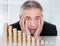 Shocked businessman with stack of coins