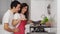 Shocked couple cooking and preparing food in the kitchen at home. man in hugging woman