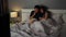 Shocked couple is watching horror movie TV on a bed at night