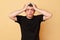 Shocked despair sufferer man in black T-shirt with bruises and abrasions on his face isolated over beige background standing with