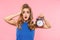Shocked displeased young pretty woman posing isolated over pink wall background holding alarm clock