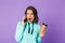 Shocked displeased young woman posing isolated over purple background wall talking by mobile phone