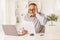 Shocked elderly man looking at a paper and sitting in front of a computer