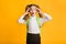 Shocked Elementary Student Girl Clutching Head Over Yellow Background