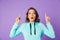 Shocked emotional young woman posing isolated over purple background wall