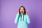 Shocked emotional young woman posing isolated over purple background wall