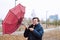 Shocked European white young male man fool around with umbrella in city park, strong storm wind, rain and bad weather. Wind broke