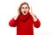 Shocked face ginger girl in red sweater looks surprised with open mouth holding head with hands