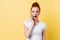 Shocked ginger woman in white t-shirt talking by the smartphone