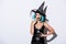 Shocked girl in black witch Halloween costume with blue hair