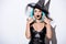 Shocked girl in black witch Halloween costume with blue hair