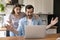 Shocked happy young family couple looking at computer screen.