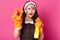 Shocked impressed cute young lady showing dirty washcloth, holding detergent in yellow bottle, opening mouth widely, wearing white