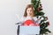 Shocked little child girl looks with opened eyes and worried expression, holding box with various plastic wastes over