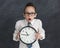 Shocked little girl holding big clock