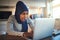 Shocked looking Arabic female entrepreneur working online at hom