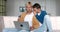 Shocked male gay couple looking at laptop screen and upset with bad news while sitting together on sofa at home