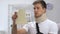 Shocked man in arm sling and cervical collar looking at medical bill, expanses
