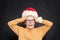 Shocked mischievous child in Santa hat  on blackboard background