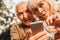 Shocked old woman and smiling man using smartphone