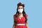 Shocked pinup lady in retro clothes wearing face mask against coronavirus on blue studio background