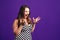 Shocked plus size model with wide open mouth on purple background