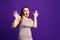 Shocked plus size model with wide open mouth on purple background