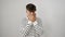 Shocked portrait of young hispanic man in stripes, hands covering mouth in shy, embarrassed silence over isolated white background