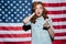 Shocked redhead young lady standing over USA flag