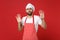 Shocked scared bearded male chef cook or baker man in striped apron t-shirt toque chefs hat posing isolated on red