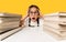 Shocked Schoolgirl Cupping Head Sitting Between Books Stacks, Yellow Background