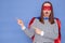 Shocked surprised Caucasian brown haired woman wearing superhero costume and striped shirt isolated over blue background