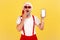 Shocked surprised man in stylish sunglasses and santa claus red hat holding smartphone with empty screen, unbelievable online