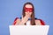 Shocked surprised scared brown haired woman wearing superhero costume and mask posing isolated over blue background working on