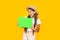 shocked teen girl with copy space on green paper on yellow background