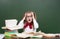 Shocked teen girl near empty green chalkboard