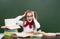 Shocked teen girl near empty green chalkboard