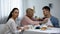 Shocked wife looking at mother-in-law putting napkin on husbands neck, tea party