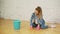 Shocked woman cleaning house with lots of tools. Young tired girl throws a rag in a bucket.