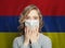 Shocked woman in medical mask on Armenian flag background. Flu epidemic and domestic violence in Armenia concept