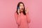 Shocked wondered woman with brown hair in pink sweater talking phone, listening to information with surprised expression,