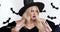 Shocked young blonde woman in witch costume surprising around, touching her face