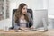 Shocked young businesswoman sitting at the office desk