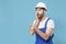 Shocked young man in coveralls helmet hardhat isolated on blue background. Instruments accessories for renovation