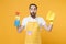 Shocked young man househusband in apron rubber gloves hold spray with washing cleanser, cleaning rag while doing