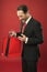 Shocking discount. Mature businessman hold paper bag gift red background. Shopping concept. Christmas gift. Happy