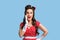 Shocking offer. Surprised young pinup woman in retro style dress opening mouth in disbelief on blue studio background