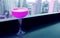 Shocking pink colored cocktail on the rooftop bar`s table with skyscrapers view in the backdrop