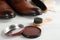 Shoe care products and footwear on white table, closeup